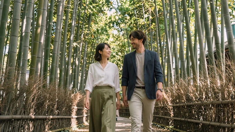Western man and Japanese woman walking through Kyoto bamboo grove - Japanese dating journey